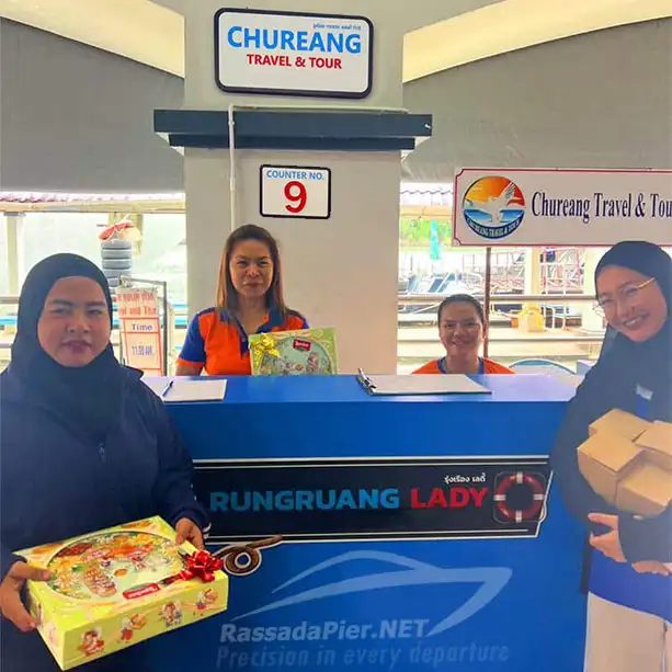 Smiling staff and passengers exchanging gifts at Counter No. 9 for Chureang Travel & Tour and Rungruang Lady ferry departures at Rassada Pier